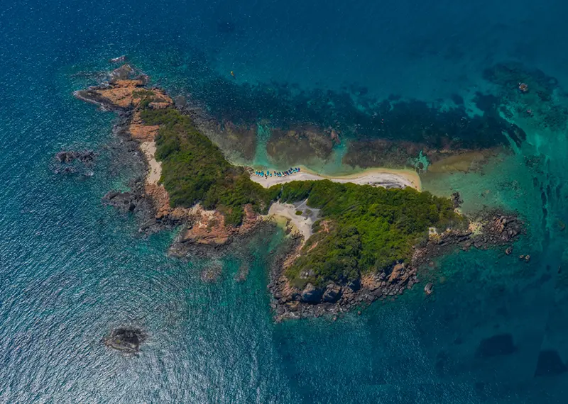 Stunning drone shot of a beautiful remote tropical island and coral reefs