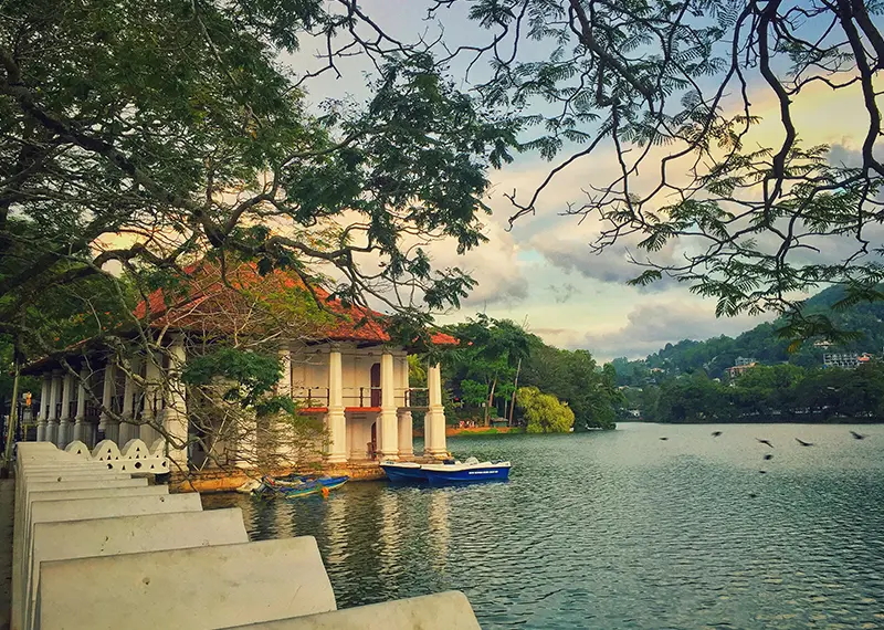 Historic colonial architecture reflecting on the calm waters of beautiful Kandy Lake