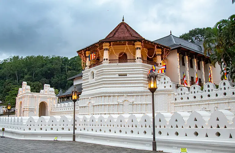 A beautiful view of the historic Sri Dalada Maligawa temple complex decorated with lights, representing the rich spiritual destinations you can explore on custom Sri Lanka religious tours