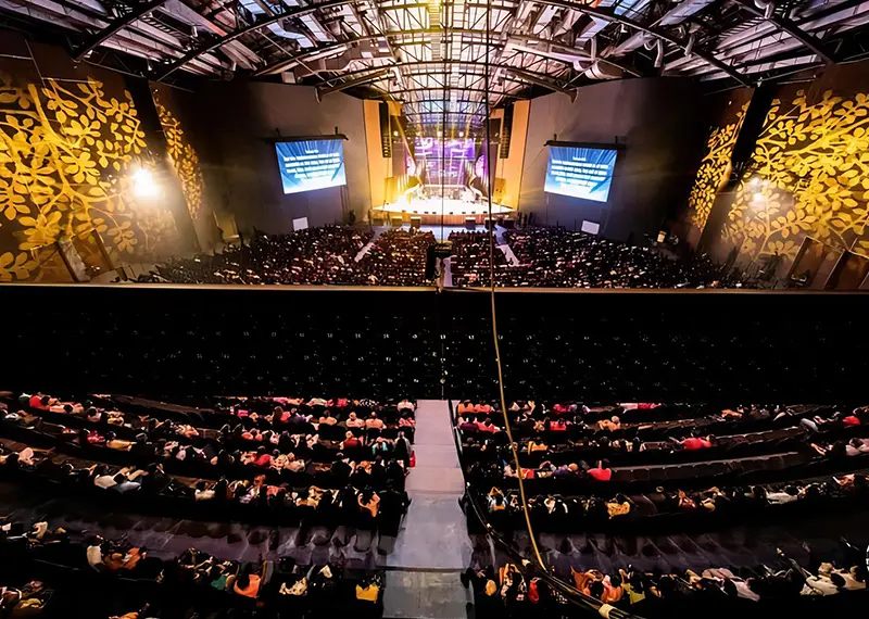 High angle view of an audience gathered inside a grand auditorium hall