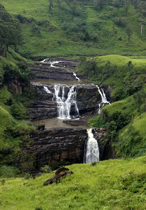 A stunning cascading waterfall surrounded by lush green tea estates, a scenic hill country highlight included in our Highland Wonders & Tea Trails tour packages