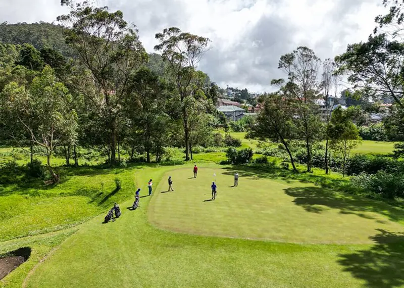 Golfers enjoy a peaceful game on a lush highland golf course green