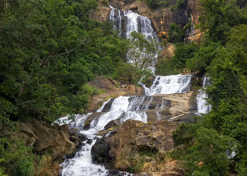 Majestic tiered waterfall tumbling down rocky slopes during a scenic nature hike