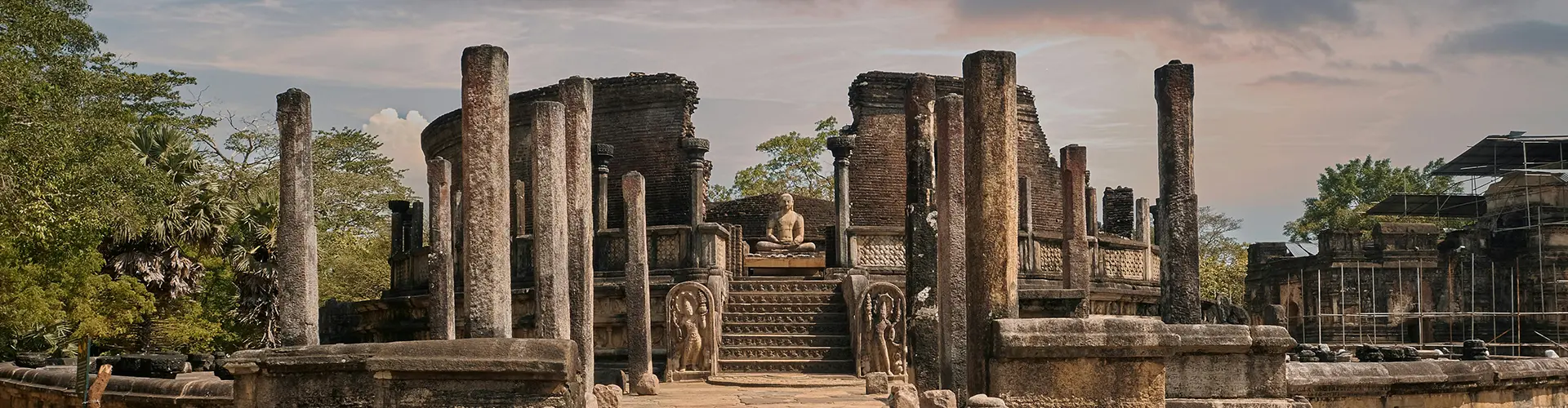 The intricately carved stone steps and pillars of the ancient Polonnaruwa Vatadage leading to a seated Buddha statue, highlighting the historical landmarks included in our Sri Lanka Ancient Echoes & Emerald Highlands package.