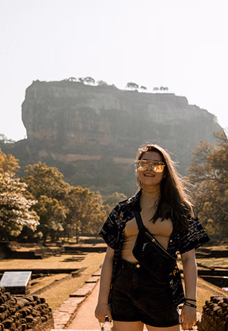 A female traveler enjoying a sunny day at the ancient ruins of Sigiriya during her private Sri Lanka tour focused on culture and heritage