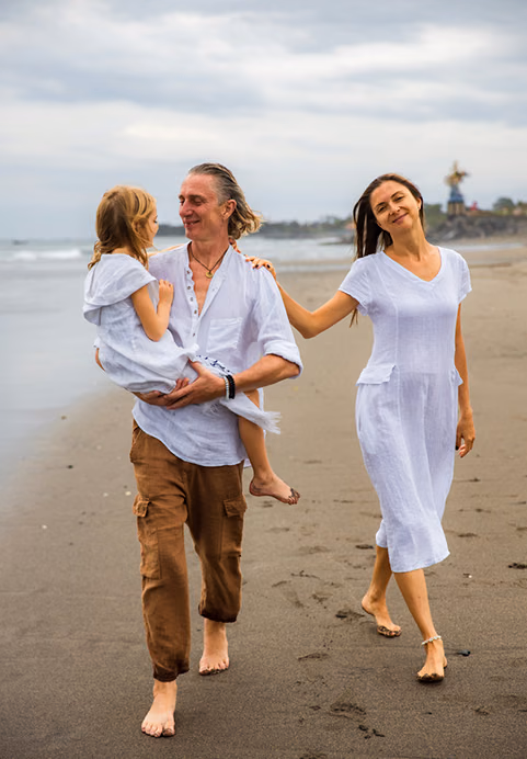 A happy family strolling along a sandy beach in Sri Lanka, enjoying quality time on their relaxing family holiday package