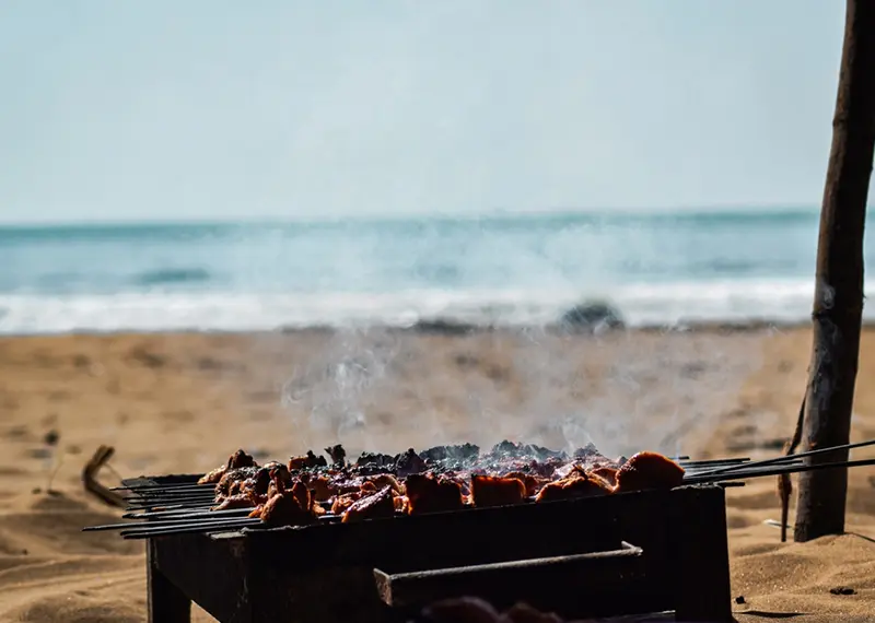 Delicious food grilling on skewers on a sunny beach in Sri Lanka