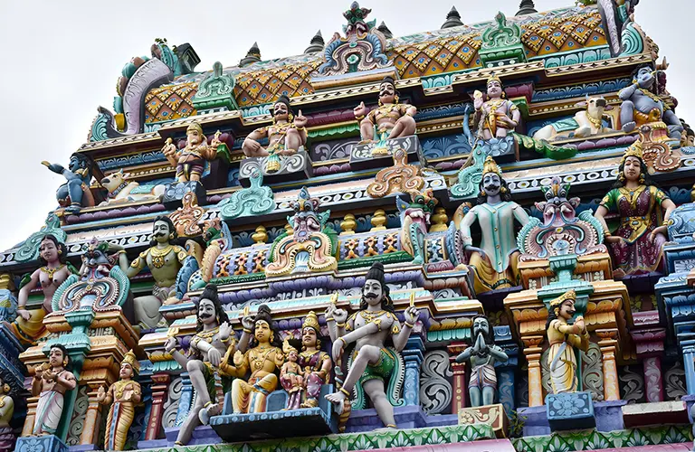 A close-up view of a vibrant Hindu temple tower adorned with colorful, intricate deity sculptures, showcasing the rich cultural heritage included in our Sri Lanka ramayana tour packages.