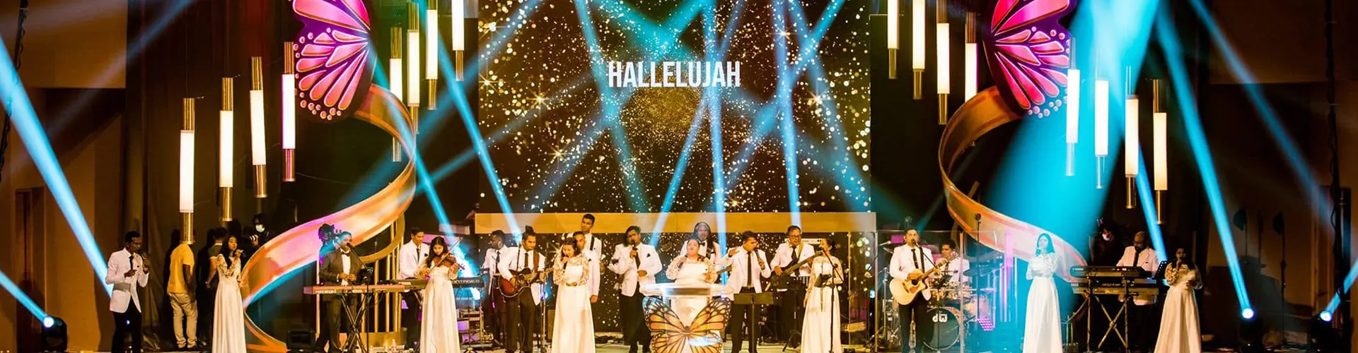 A vibrant illuminated stage filled with musical performers under bright colorful lights included in The Grand Miracle Dome & Island Odyssey package