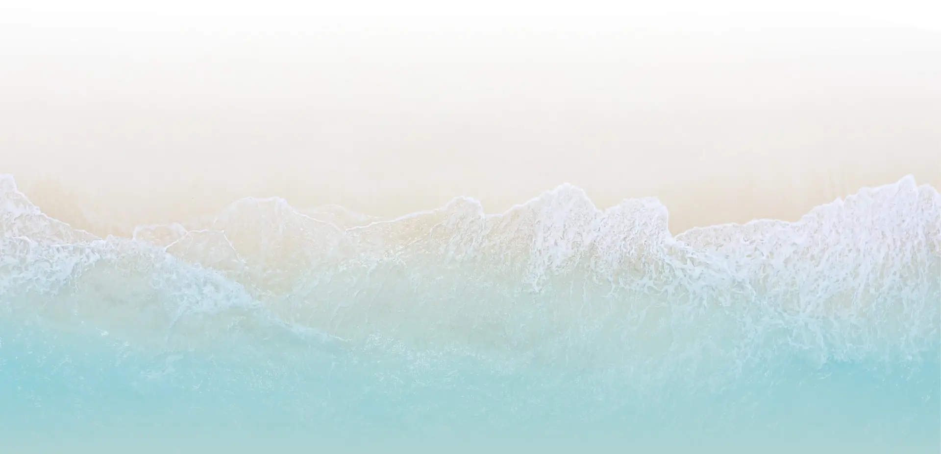 An aerial view of gentle turquoise waves washing onto a pristine white sand beach, representing the tranquil coastal escapes included in our Sri Lanka tour packages
