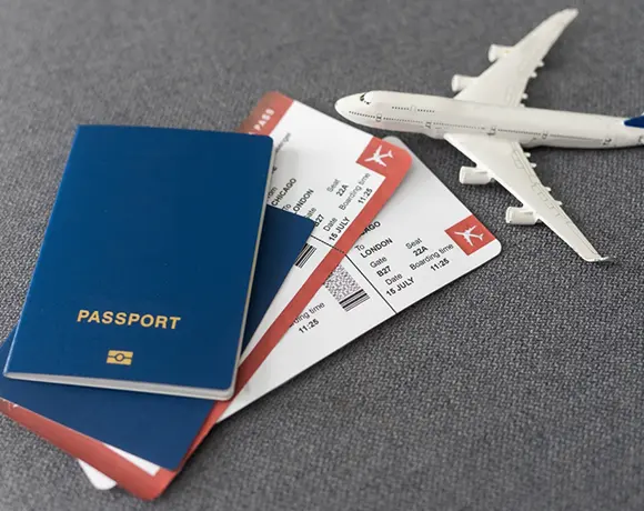 Essential travel documents including a passport and flight tickets next to a toy plane, highlighting the seamless travel planning and ticketing services provided for custom Sri Lanka tours